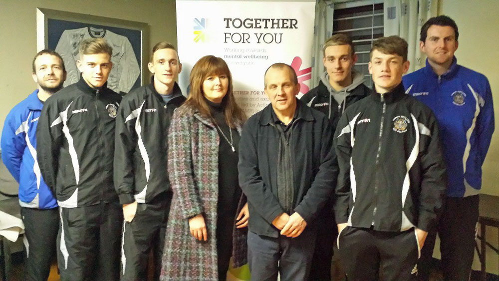 Andrea Warwick, Employment Officer at Action Mental Health in Derriaghy joins members of Lisburn Distillery Football Club as they benefit from one of their MenSsana “Provoking Thought” workshops for young people, part of the Together For You project, funded by the Big Lottery Fund.