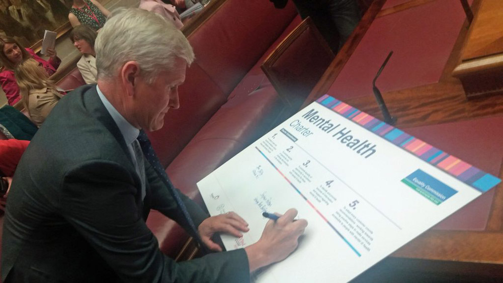 David Babington, Chief Executive of AMH, signs the Mental Health Charter