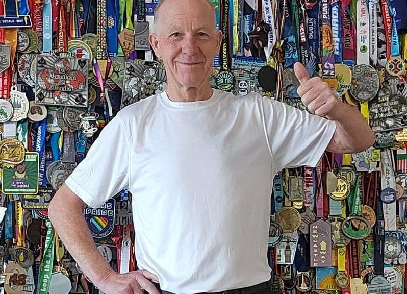 Oggie giving the thumbs up in front of his wall of medals