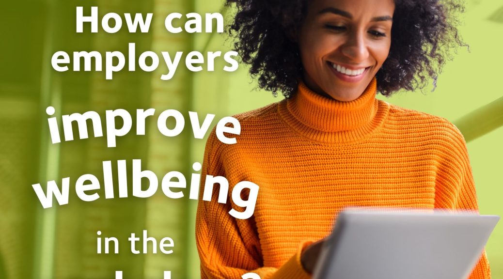 A woman smiling and reading on a tablet. There is overlaid text which reads: How can employers improve wellbeing in the workplace?