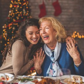A young woman and her grandmother enjoying a Christmas dinner.
