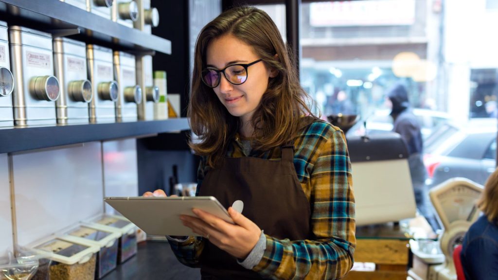 A cafe worker reading a tablet.