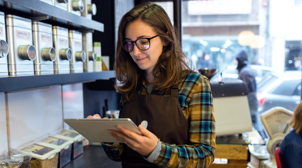 A cafe worker reading a tablet.