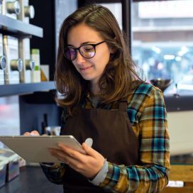 A cafe worker reading a tablet.