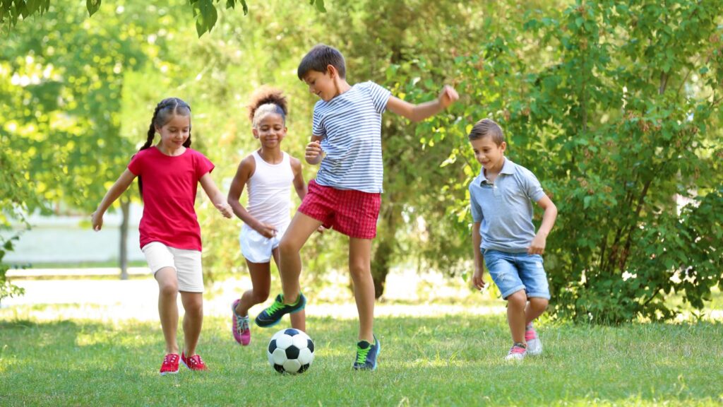 Children playing football in a park.