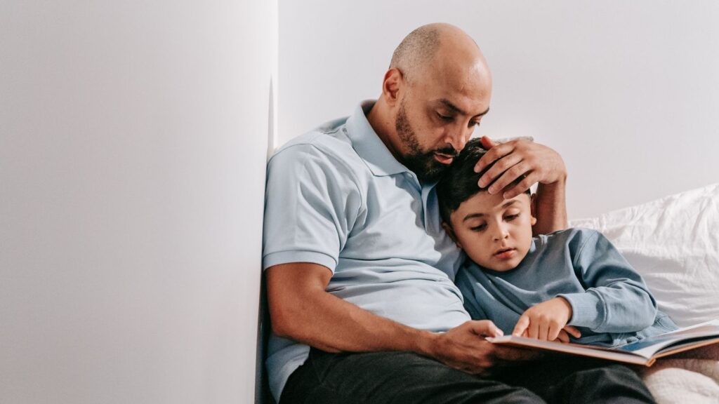 A father reading a book with his son before bedtime.