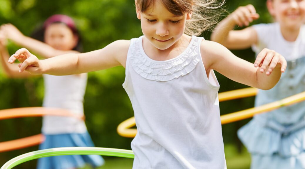 A group of girls playing with hula hoops.