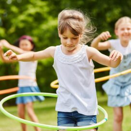 A group of girls playing with hula hoops.