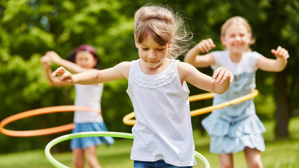 A group of girls playing with hula hoops.